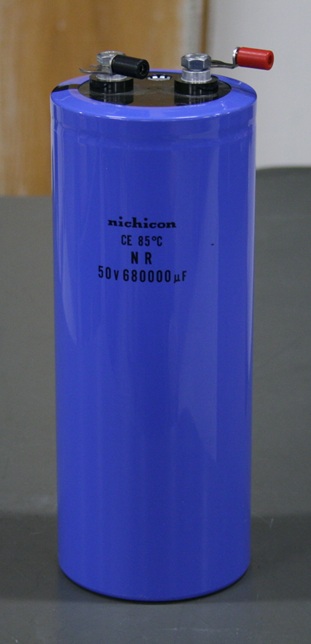 Cylindrical capacitor the size of a large water bottle, marked 50 volts and 680000 microfarads, with terminals on top.