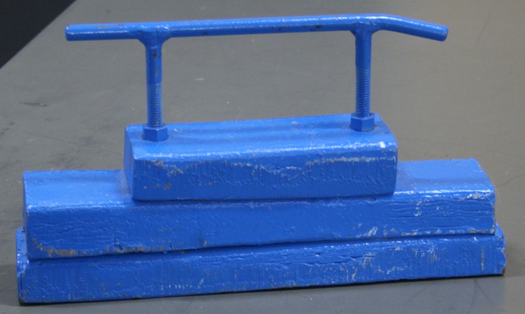Three blue-painted lead blocks bolted in a stack with a steel handle.