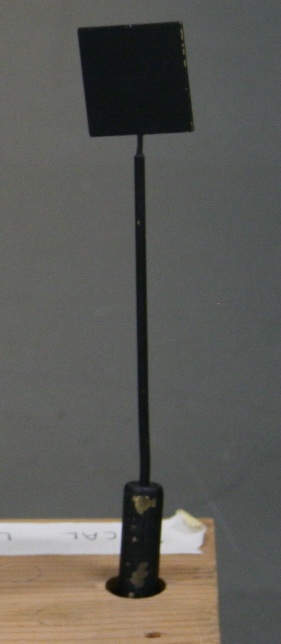 Small metal square mounted on a thin metal stem.