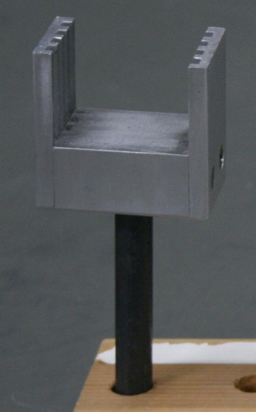 Aluminum frame 2 inches square with 4 slots for 35 mm slides, mounted on a short metal rod.