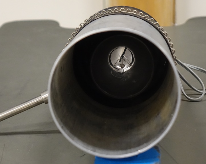 300 watt clear incandescent bulb with horseshoe-shaped filament housed in a cylindrical aluminum hood, about a forearm long and a handspan wide, with attached rod.