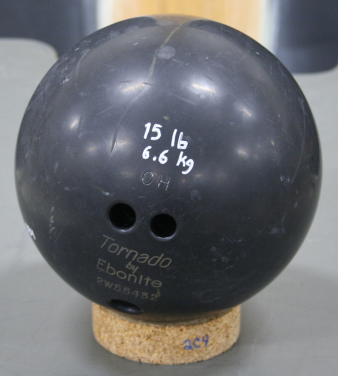 Bowling ball marked 15 lb and 6.6 kg, with multiple imperfections in the surface.