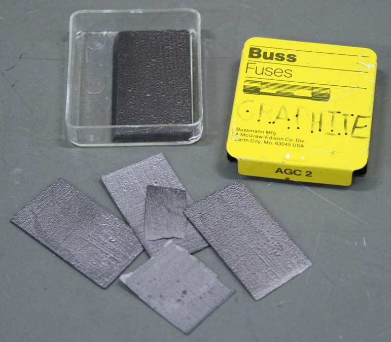 Several rectangular flakes of graphite, each about one inch by half an inch, or smaller.