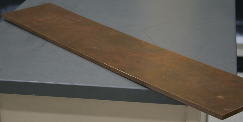A copper plank 30 inches long, 6 inches wide, and 3 eighths of an inch thick.