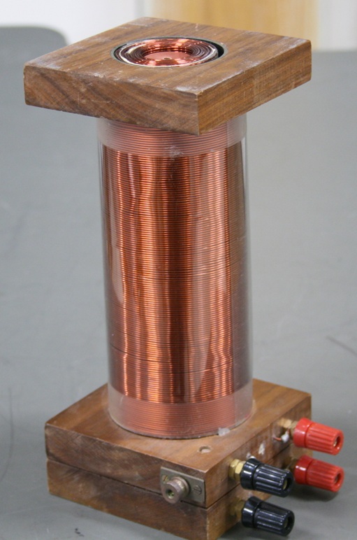 An iron-core solenoid fits neatly inside a larger air-core solenoid.  Each coil has a pair of banana-plug terminals.