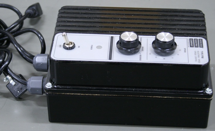 A rectangular motor control box, showing its speed and direction dials and power switch.