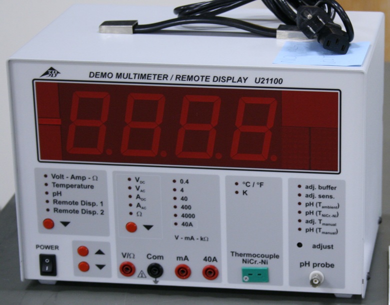 The multimeter is a rectangular white box about the size of a small cooler.  It has a four-digit red LED deisplay two inches tall, four banana sockets, a thermocouple port, and a BNC pH probe connector.