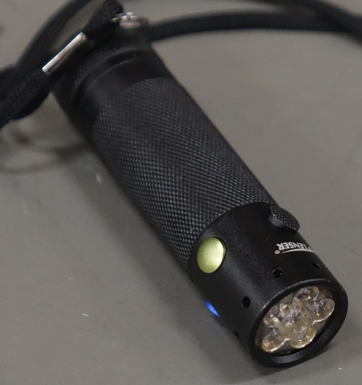 A small flashlight with 5 LEDs: three white, and one each of red, green, and blue.  Buttons around the barrel control each color independently.