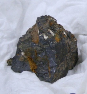A roughly cubic piece of lodestone about an inch across, with sight rusting.