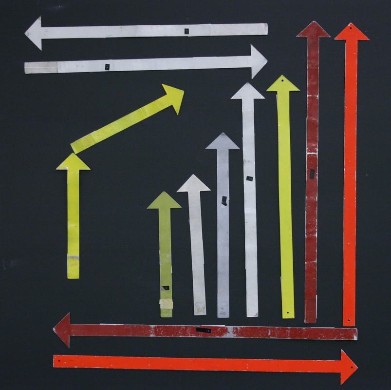 Full set of magnetic vector arrows displayed on a blackboard — various lengths in white, yellow, red, and orange, arranged vertically and horizontally