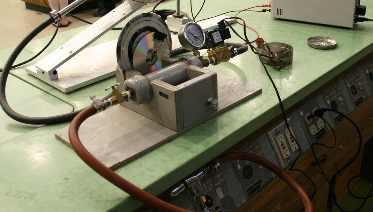 Ballast tank with pressure gauge, solenoid valve, and air hoses on a green lecture bench