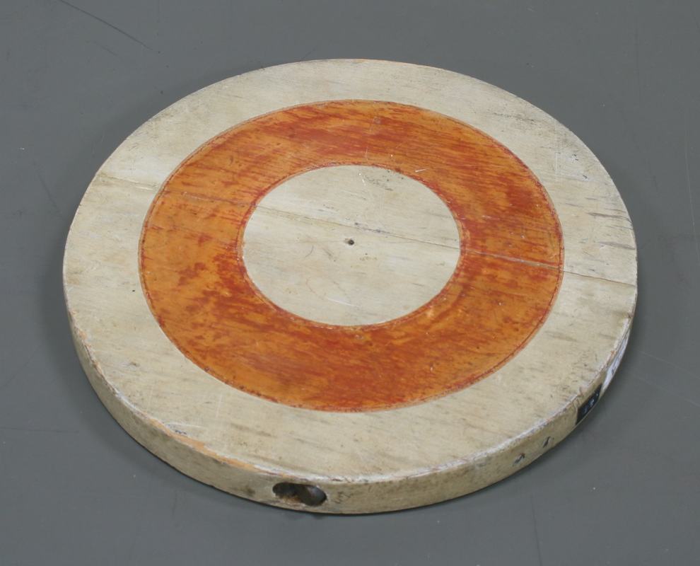 Opposite side of wooden disk with orange ring painted around the offset center of mass