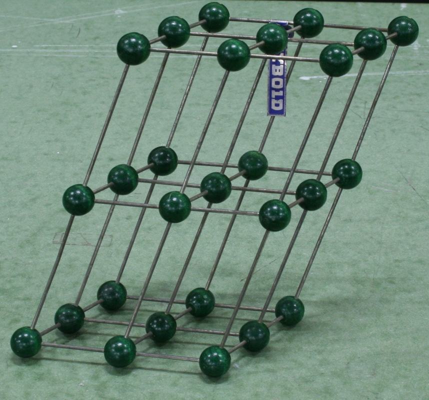 Single Leybold crystal model with dark green spheres connected by metal rods in a face-centered cubic arrangement
