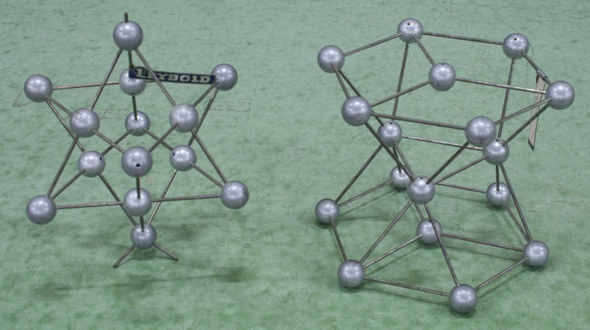 Two silver metallic Leybold polyhedral models showing cage structures with approximately twelve vertices each