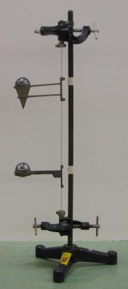 Torsional oscillator: a vertical stand with a torsion wire connecting two horizontal arms at different heights, each with a cone or ball mass on one end and a clamp on the other