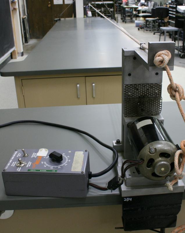 Close-up of the motor driver end showing the speed control box with switches and dial, connected to the motor with metal housing and rope knotted into the drive mechanism