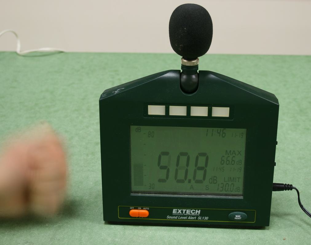 Extech SL130 sound level meter reading 90.8 dB as a fist pounds the table beside it, with MAX display showing 66.6 dB from an earlier measurement, set to 30-80 dB range