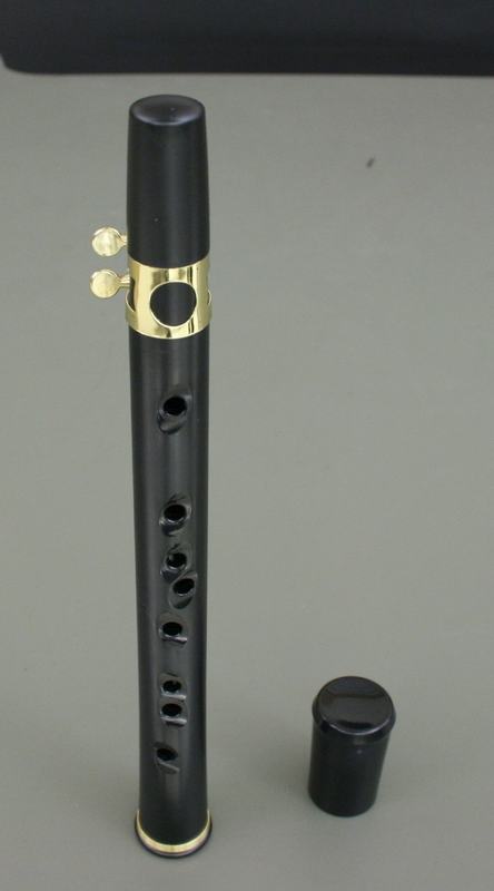 Black Xaphoon with gold ligature and mouthpiece, finger holes along the body, removable black end cap shown beside it