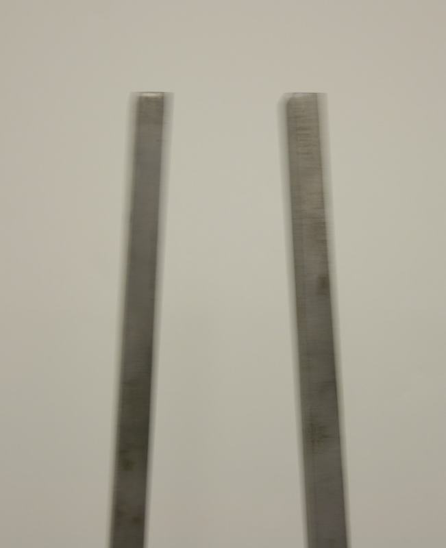 Close-up of the two flat rectangular steel tines of the giant tuning fork