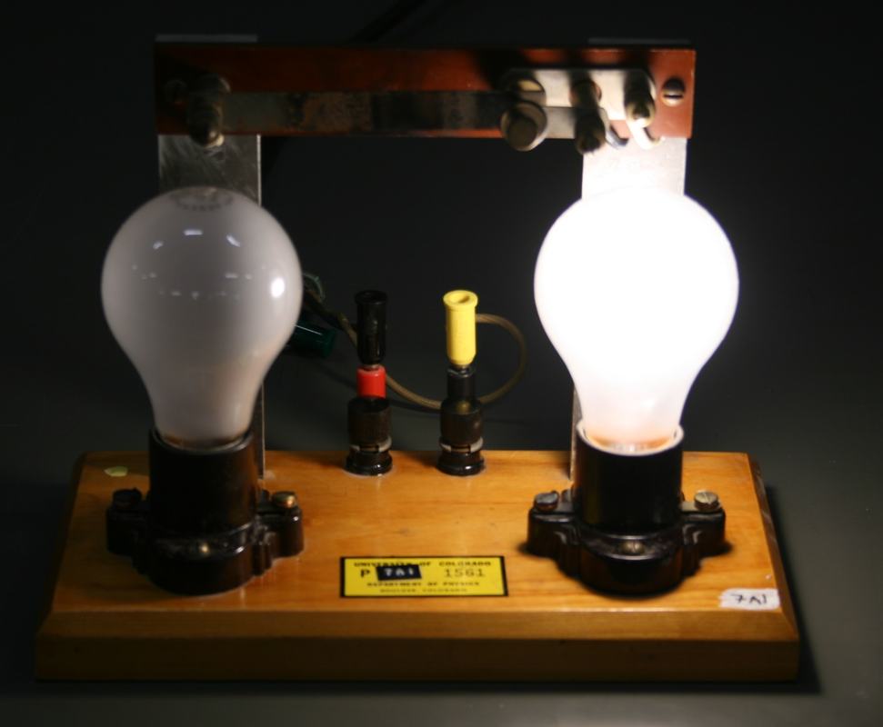 Thermostat apparatus with right bulb illuminated and left bulb dark after heating the bimetallic strip