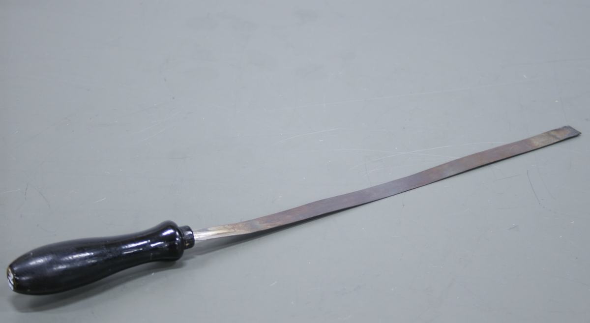 Straight bimetallic strip with black wooden handle on a gray surface