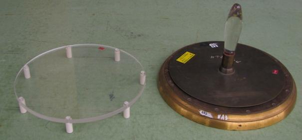 Auxiliary Lucite plate on plastic standoffs (left) and electrophorus with dark metal plate, insulating handle, on brass-rimmed wooden base (right)