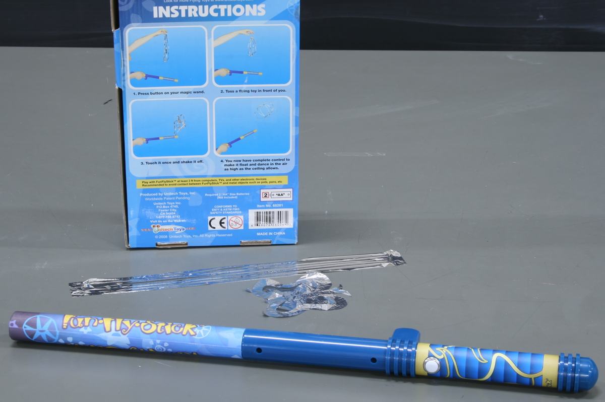 Blue Fun Fly Stick wand with instruction box and transparent foil figures on gray surface