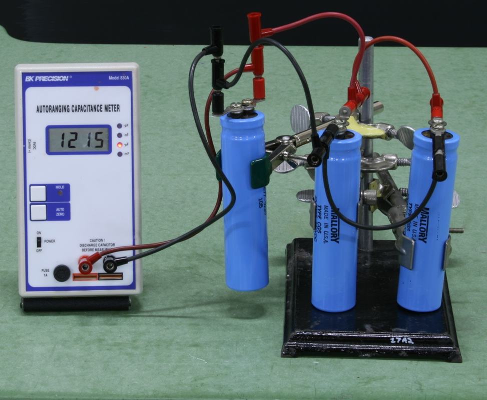Same three blue Mallory capacitors on stand, rewired in parallel to the BK Precision capacitance meter now reading 1215 µF