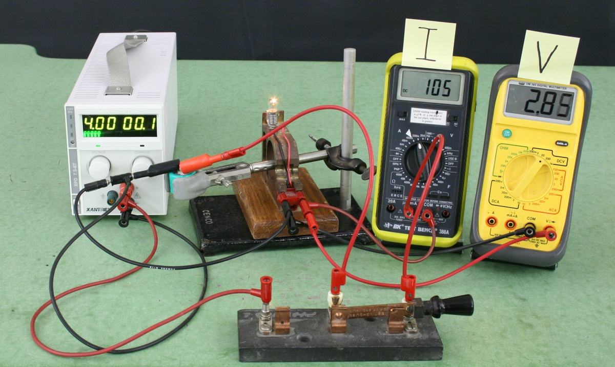 Same RC circuit with power supply at 4.00V, bulb glowing brightly, ammeter reading 105 mA, voltmeter reading 2.85V