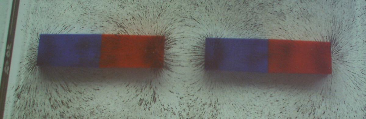 Two bar magnets with opposite poles facing each other, iron filings showing field lines connecting between the adjacent poles