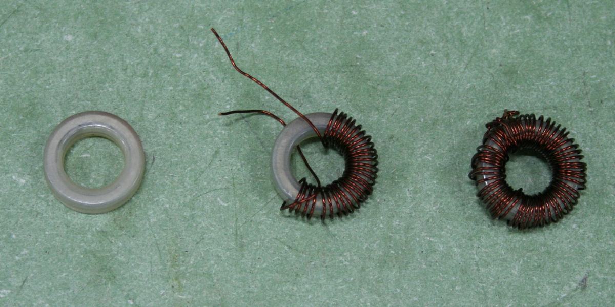 Three toroidal cores in progression: bare gray ferrite ring, partially wound with copper wire, and fully wound inductor with dense windings