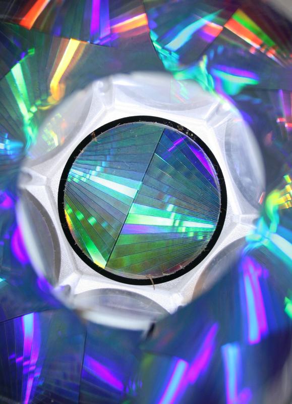 View through the holoscope showing rainbow diffraction patterns from the holographic disk, reflected multiple times by the 13-segment reflective tube