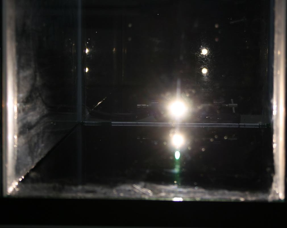 Same tank setup with a different ripple pattern; the lamp reflection appears as a bright spot with a shorter vertical streak below