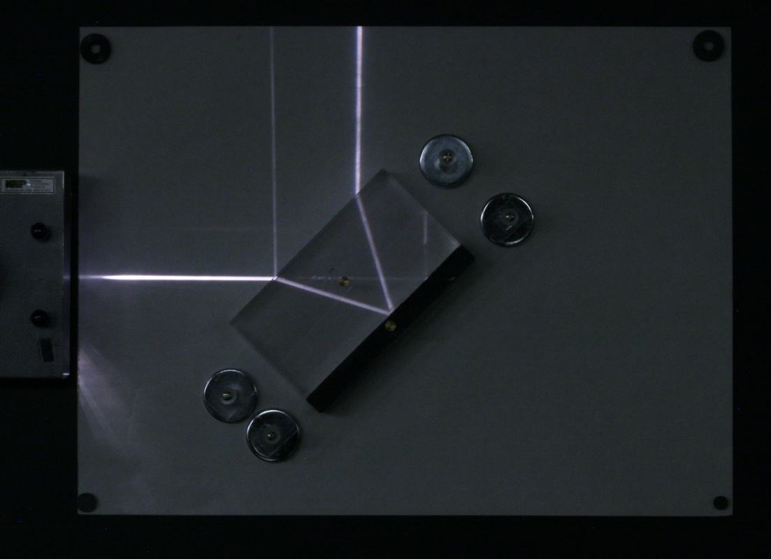 Single light ray entering a rectangular plexiglass block at a steep angle, showing total internal reflection at the far surface