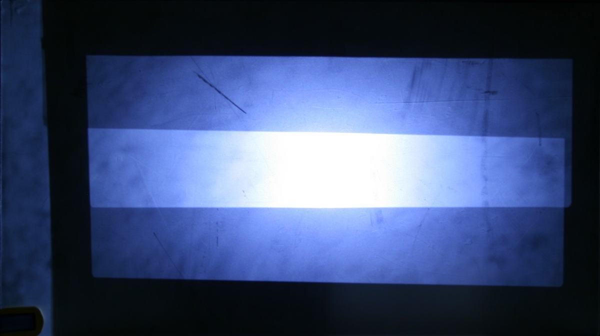 Translucent screen showing a bright central band where both flashlights illuminate, with dimmer bands above and below where only one flashlight reaches