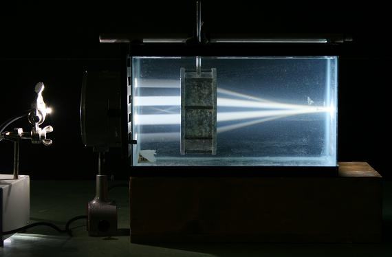 Darkened room: collimated light beam enters the aquarium from the left, passes through a convex air lens, and diverges after exiting the lens