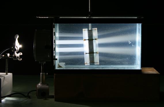 Darkened room: collimated light beam enters the aquarium from the left, passes through a concave air lens, and converges after exiting the lens