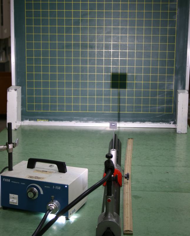Same setup with barrier moved closer to light source; a small dark shadow square is visible on the gridded chalkboard