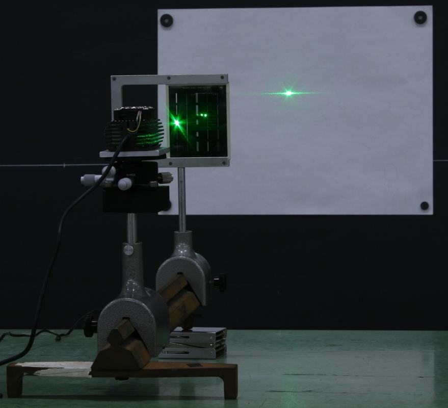 Green laser and Cornell diffraction plate mounted on optical rail, with single-slit diffraction pattern projected on white paper attached magnetically to the blackboard