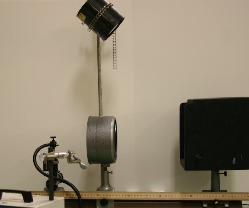 Optical bench setup with mercury lamp on tall stand at left, projection lens on center support, meter stick along bench, and soap film interference box at right