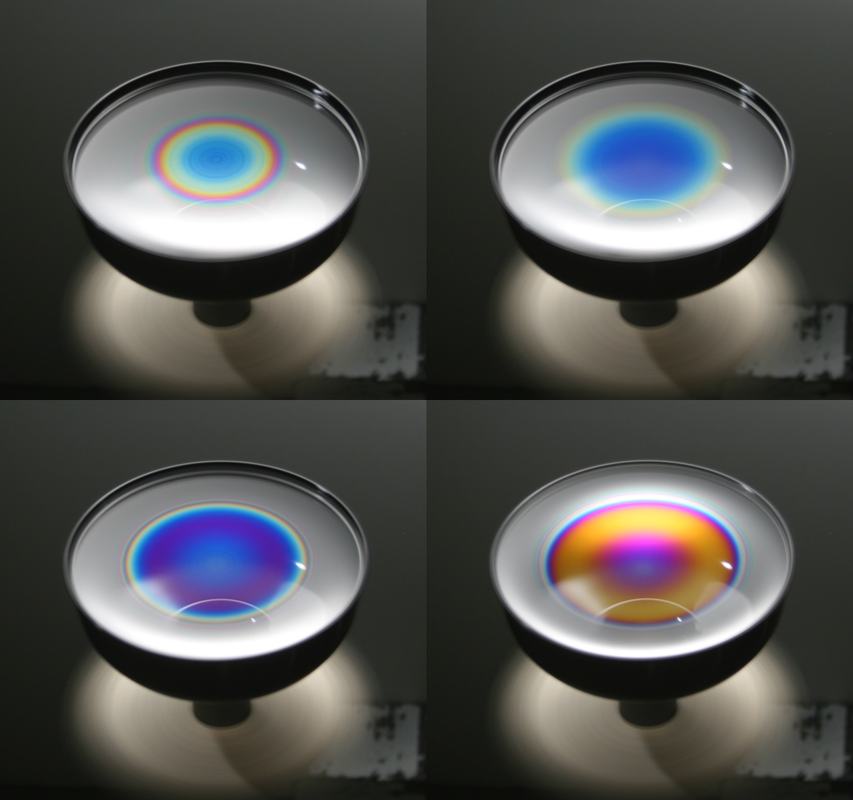 Four views of a spinning soap film in a black cup under white light, showing evolution from small concentric rainbow rings at center, to expanded blue central region, to blue-purple field, to large gold and magenta interference pattern