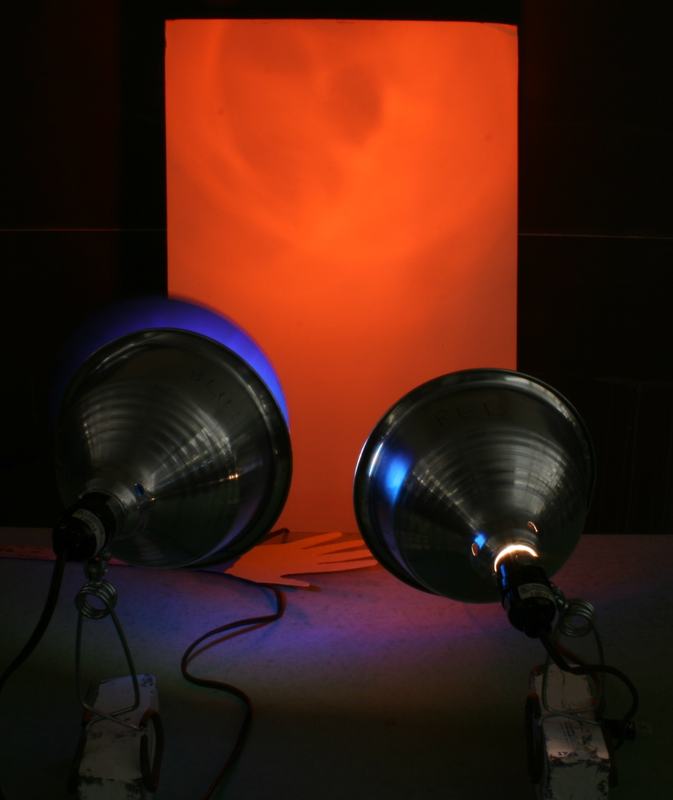 Screen glowing bright orange-red with both flood lamps visible; only the red lamp is on