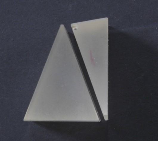 Top view of two glass prisms placed together with apexes pointing in opposite directions, forming the achromatic combination