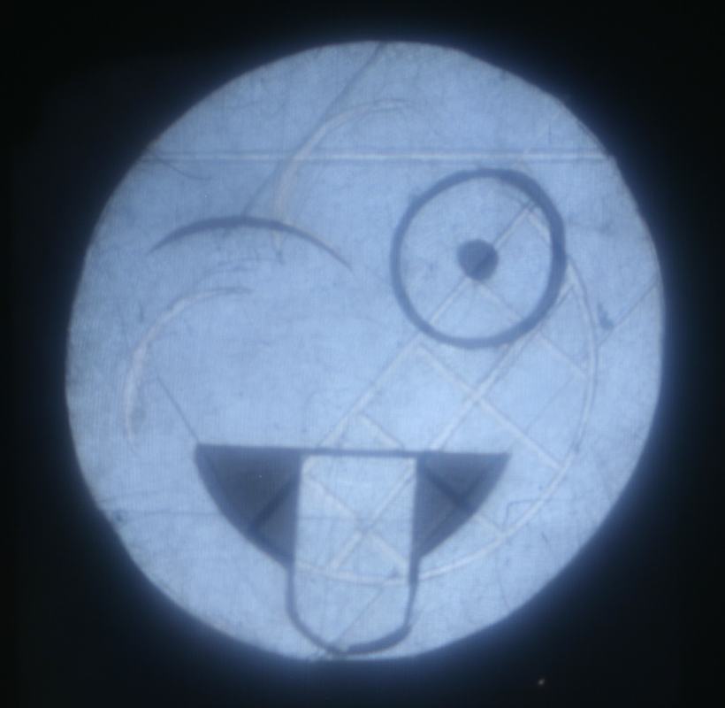 Emoji face plate rotated further, now showing a winking face sticking out its tongue