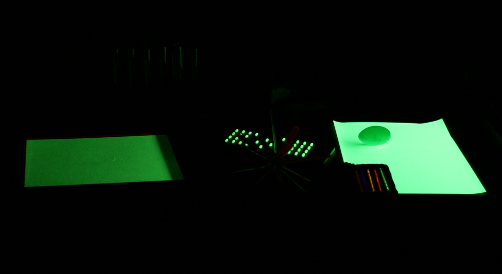 UV light turned off — only phosphorescent items continue glowing green in the dark
