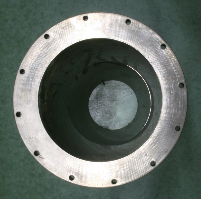 Top-down view into the circular mirror assembly showing concentric reflecting surfaces and a mounting flange with bolt holes